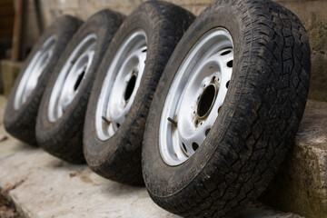 Wheels with old worn-out car tires.
