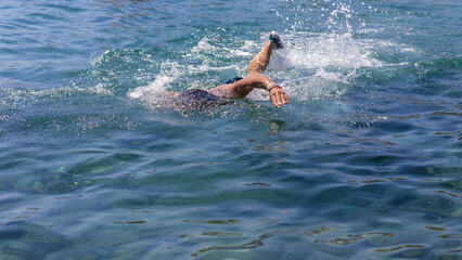 A man swims in the sea. Selective focus.