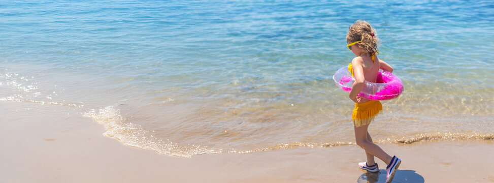 Child with a ring on the sea. Selective focus.