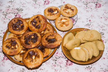 Homemade sochniki with cottage cheese and shangi lie on a tray.