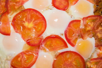 Close-up of fried eggs with tomatoes.