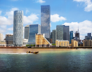 Fototapeta premium Canary Wharf Skyline with Speedboat on the River Thames, London