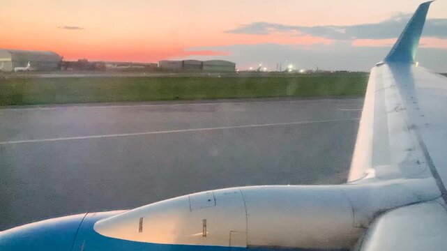 Plane takeoff view from the window Runway sunset pink