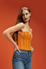 Youthful beauty in vibrant orange against a warm backdrop, showcasing elegance and style
