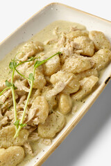 Delicious potato gnocchi with chicken and pesto sauce, sprinkled with parmesan cheese