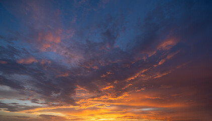 Dramatic sunset sky covered with colorful yellow clouds. Panoramic skyscape