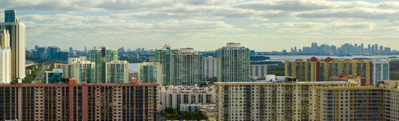 Fototapeta premium High angle view of Sunny Isles Beach city with expensive highrise hotels and condo buildings on Atlantic ocean shore. American tourism infrastructure in coastal southern Florida