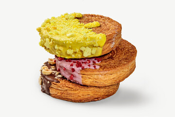 Stack of cronuts with yellow, pink and chocolate topping forming a delicious dessert
