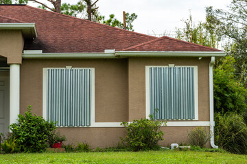 Residential house in Florida with reinforced storm shutters for hurricane protection. Window covering as disaster preparedness