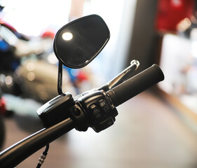 Close up of motorcycle controls with rear view mirror on blurred background