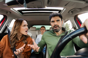 Family having quarrel in car, woman shouting at man driving auto, having problem in relationships,...