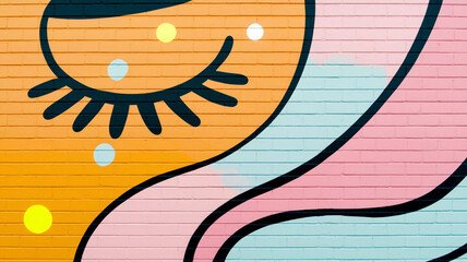 A playful and colorful pop art mural featuring a winking eye and abstract shapes on a vibrant brick wall