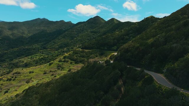 Smooth drone ascent over Teno mountain ridge with winding serpentine road and Tenograd Masca village at the summit, Tenerife, Canary Islands