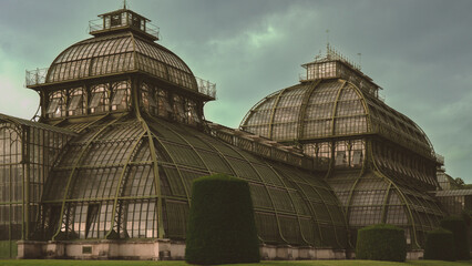 Fototapeta premium Historic Glass Conservatory Architecture in Europe Under Dramatic Green Sky