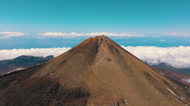 Aerial view of Mount Teide and surrounding lava flows above sea of clouds at sunset in Teide National Park, Tenerife