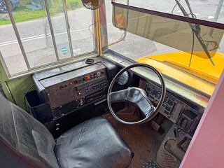 The interior view of a cab of an old school bus from the 80s