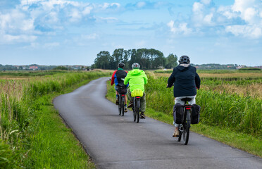 Senior people in outdoor clothes driving through the nature reserve in Uitkerke, West Flanders, Belgium