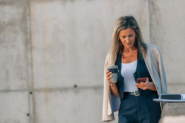 businesswoman on break with a cup of coffee and a cell phone