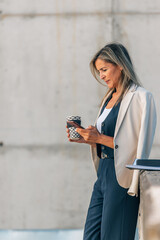 businesswoman on break with a cup of coffee and a cell phone
