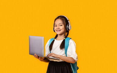 Distance Learning. Asian School Girl With Laptop And Headphones Listening To Educational Podcast...