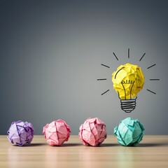 Crumpled paper balls representing ideas with one bright illuminated light bulb