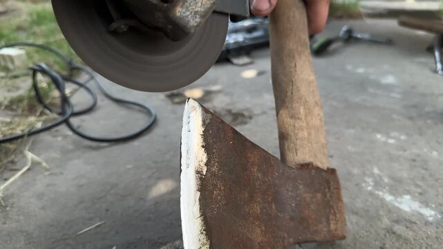sharpening an axe with a grinder closeup. High quality 4k footage
