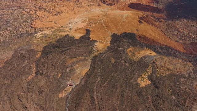 Aerial view of dark lava rivers on Mount Teide contrasting with lighter volcanic layers, Tenerife, Canary Islands