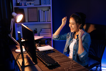 Host channel Asian influencer talking in broadcast streaming online wearing headsets on social media with pc recording, greeting listeners and coaching market online at neon modern studio. Stratagem.