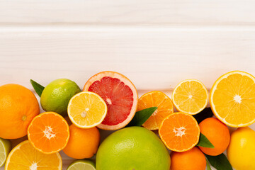 Different citrus fruits on wooden background, top view
