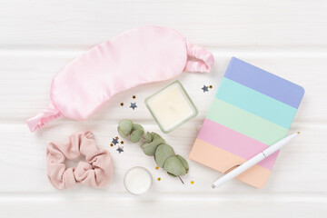 Sleeping mask with accessories on wooden background, top view. Sleeping routine concept