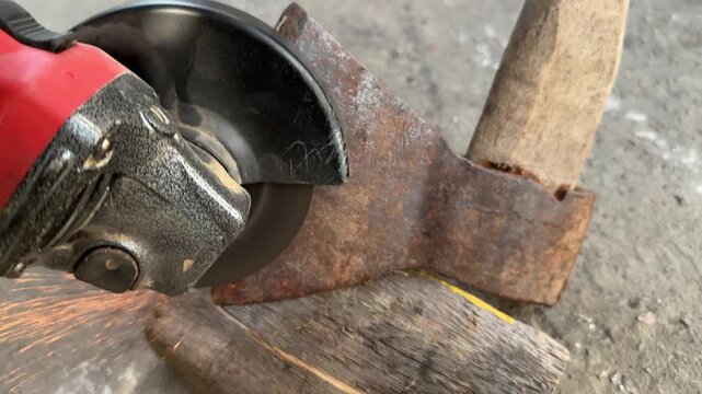 cleaning and sharpening an old rusty axe with a grinder. High quality 4k footage