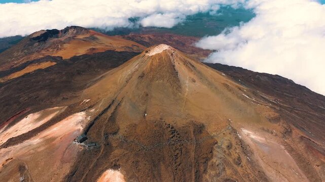 Aerial view of Mount Teide and surrounding lava flows above sea of clouds at sunset in Teide National Park, Tenerife