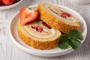 Two pieces of strawberry roll on a white plate