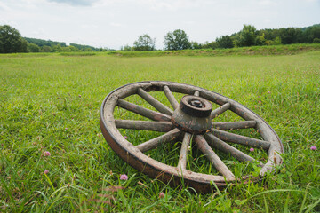 A Wooden Wagon Wheel in a Field