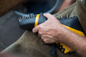 Craftsman assembling spiked shoe with precision and skill
