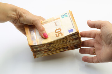 Woman's hand offering money to a man's hand