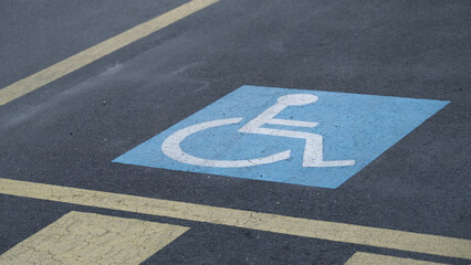 Blue wheelchair accessible parking sign on asphalt