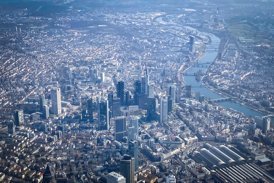 Aerial view of Frankfurt am Main, Germany, showing the skyline with high-rise buildings, the Main River, and central train station on a clear day seen from an airplane