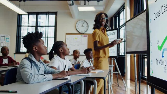 Experienced african american educator demonstrating economics on digital whiteboard while engaging diverse elementary students during interactive learning session
