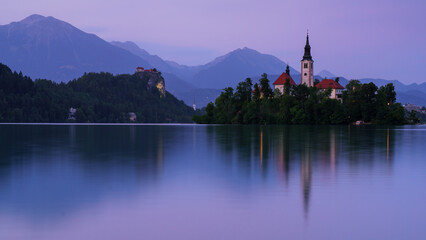 Fototapeta premium Peaceful twilight over Lake Bled with island church and mountain reflections