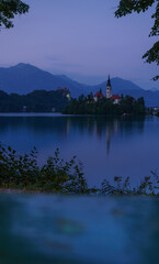 Obraz premium Peaceful twilight over Lake Bled with island church and mountain reflections