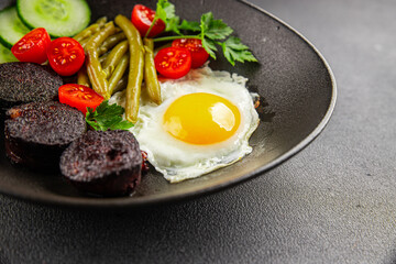 English breakfast fried egg, black pudding, vegetables, beans fresh delicious gourmet food background on the table rustic food top view copy space