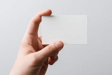 Obraz premium Realistic view of hand holding a blank index card against a simple white background while preparing notes or organizing thoughts