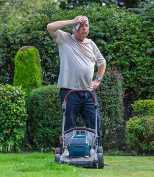man hot and tired cutting the grass