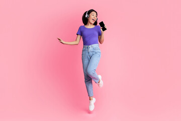 Carefree Singer. Asian lady singing favorite song and using cell phone as a mic, dancing and...