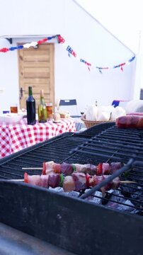 Chilean Independence Day vertical video: Woman places anticuchos on grill during traditional celebration with decorated terrace in background