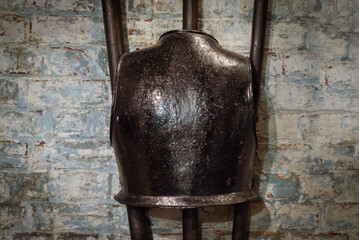 Close up of ancient medieval breast plate armour hanging on wall at Westgate Tower in Canterbury, UK