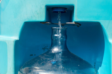 Water pours from the machine into a 19 liter bottle