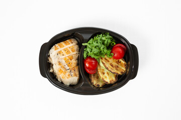 Grilled chicken fillet with grilled vegetables on a plate on a white background
