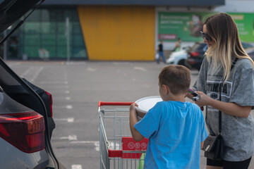 Mom and her son loading groceries into the car
